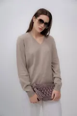 Sweater color beige de cashmere con escote en V y mangas largas.
