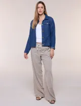 Campera de denim liviano azul, de corte clásico y silueta recta, con cuello camisero, cierre frontal con botones rústicos y bolsillos con solapa en el pecho.