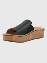 Sandalia tipo slide de Hush Puppies con capellada de cuero negro y banda elástica lateral. Presenta una suela de plataforma alta con acabado de corcho y base de caucho.