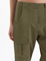 Pantalon cargo de tiro alto color verde militar, confeccionado en sastrero elastizado, con multiples bolsillos con tapa en los laterales y diseño de pernera ancha.