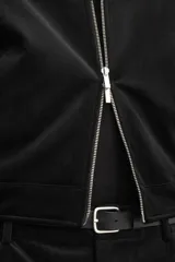 Sobrecamisa de corte cropped confeccionada en terciopelo con elasticidad. Presenta cuello solapa, cierre frontal con cremallera metálica, bolsillos de vivo en la cadera y mangas largas con puños abotonados.