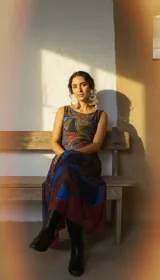 Vestido largo sin mangas, de tul estampada con motivos abstractos en tonos rojo arcilla, azul profundo y verde olivo.