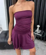 Vestido corto color uva, con diseño strapless, cuerpo ajustado con frunces y falda con volados en capas.