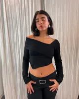 Pantalón negro de corte ajustado con cintura baja y hebilla plateada.