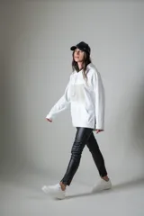 Calzas negras de cuero sintético con corte ajustado y cierre en los tobillos.