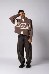 Campera tejida de punto con cierre frontal completo, cuello tipo polo y diseño con franja horizontal en contraste con estampado gráfico. Presenta puños y ruedo acanalados, con corte holgado.