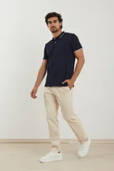 Chomba azul marino de piqué con cuello clásico y tapeta de dos botones. Detalles de ribete blanco en cuello y mangas.