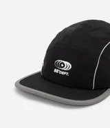 Gorra negra de microfibra, modelo 5 panel, con visera plana y logo estampado en blanco.