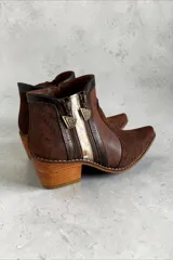 Botas cortas de cuero marrón jaspeado con detalles pintados a mano en tonos dorados, con taco cuadrado de altura media, punta fina y cierres laterales decorativos.