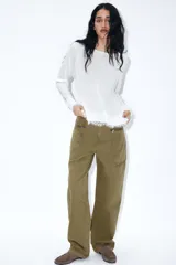 Jersey de cuello redondo y manga larga, color blanco, con bajo acabado en encaje combinado a tono.