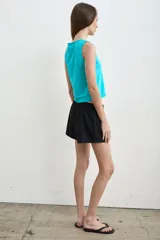 Short color crudo de tiro bajo, con pretina elástica y detalles laterales en marrón y verde militar.
