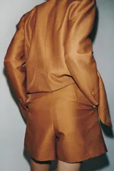 Blazer entallado color tostado confeccionado con lino. Cuenta con cuello solapa, manga larga con hombreras y cierre frontal con dos botones forrados a tono. Presenta forrería interior blanca.
