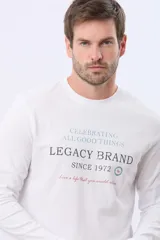 Remera blanca de manga larga con cuello redondo y estampado frontal que incluye las frases "Celebrating All Good Things", "Legacy Brand Since 1972" y "Live a life that you would live".