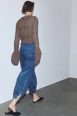 Pantalón de jean estilo bombacho con tiro medio, confeccionado en denim azul con costuras verticales decorativas y puños ajustados en el ruedo.