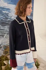 Cardigan de punto azul marino con cuello tejido a mano en crochet color crudo, cierre frontal con botones y detalles en tono borravino y crudo en los bordes y puños semióxford.