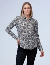 Camisa estampada blanca y negra con cuello clásico, abertura frontal con botones ocultos y mangas largas con puños abotonados.