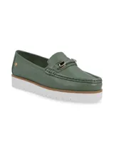 Mocasín de cuero color verde esmeralda con suela dentada blanca y detalle de hebilla metálica en el empeine.