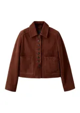 Chaqueta corta de piel de cabra color marrón, con solapas clásicas, cierre frontal de botones y bolsillos de parche.