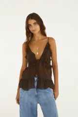 Blusa marrón de tirantes finos con escote en V pronunciado, adornada con volados a lo largo del escote y tiritas para atar en el frente.