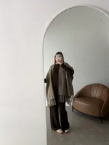 Ruana negra de tejido liviano con terminación de flecos en el ruedo y mangas amplias.