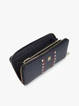 Billetera rectangular con cierre de cremallera perimetral, confeccionada en poliuretano con acabado granulado. Presenta un diseño en color azul marino con dos franjas verticales decorativas formadas por pequeñas piezas en rojo y blanco, y el monograma TH metálico en el centro.