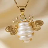 Cadena de eslabones finos con baño de oro y dije en forma de abeja con cuerpo de perla y detalles dorados.