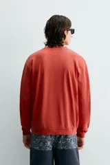Sudadera de cuello redondo y manga larga, con ajuste regular y efecto lavado. Presenta acabados en rib en puños y ruedo, confeccionada en tejido de algodón con interior de rizo.