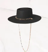 Sombrero negro de ala ancha y copa recta, confeccionado en lana merino uruguaya, con cadena dorada decorativa.