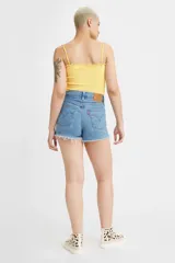 Short de jean de tiro alto con ruedo deshilachado y cierre frontal con botones, en un tono azul medio.