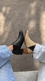 Botinetas de cuero color beige claro con inserciones elásticas laterales en negro y taco cuadrado de madera. Presentan punta fina y tirador trasero.