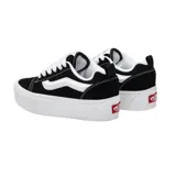 Championes Vans modelo Knu Stack, con diseño de plataforma alta, confeccionados en gamuza negra con la icónica banda lateral en blanco y cordones gruesos.