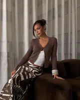Cardigan de punto marrón brillante, de manga larga y escote en V, con cierre frontal de botones y diseño entallado.