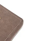 Billetera grande de símil gamuza color gris topo, con cierre perimetral dorado y herrajes metálicos dorados. Presenta el logo "XL Extra Large" en dorado en el frente. Cuenta con compartimento interno con divisor central y cierre, múltiples espacios para tarjetas y bolsillos internos para billetes.