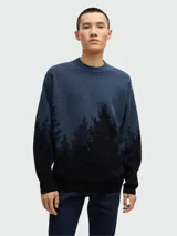 Sweater de punto con cuello redondo y diseño degradado que presenta un estampado de bosque de pinos en la parte inferior, con transición de color azul a negro.