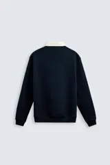 Sudadera de manga larga estilo polo con diseño de rayas horizontales anchas en azul marino y blanco. Presenta cuello de solapa en contraste, cierre frontal con botones ocultos y acabados en rib en puños y bajo.