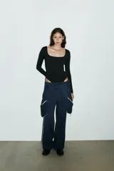 Body de manga larga con escote cuadrado, confeccionado en tejido elástico con cierre inferior mediante botones a presión.