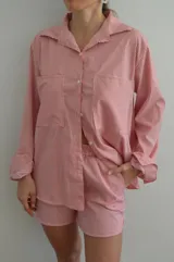 Camisa a rayas rojas y blancas de manga larga, con cuello clásico y corte holgado.