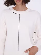 Sweater color crema de corte holgado con cuello redondo y detalle de línea vertical negra en el frente.