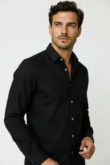 Camisa de viscosa color negro, de manga larga, con cuello camisero y cierre frontal de botones.