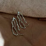 Aros colgantes con diseño orgánico inspirado en formas de coral, elaborados en metal con baño de plata y pernos de plata 925.