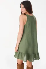 Vestido corto lila de lino, sin mangas, con escote redondo, cartera de botones de nácar en el frente y volado fruncido en el ruedo.