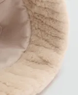 Gorro tipo bucket de pelo sintético en color beige, con textura suave y forro interior de algodón.