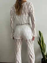 Blusa de encaje blanca con mangas largas acampanadas.