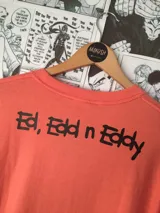 Remera color salmón con estampado de los personajes de la serie animada Ed, Edd y Eddy.