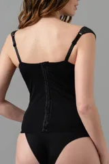 Corset largo negro con efecto lurex, copas con aro, ballenas en la parte delantera, breteles anchos regulables y ganchos reforzados en la espalda.