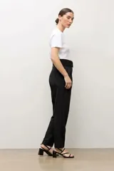 Pantalón sastrero color topo, de corte recto, con pinzas en la parte delantera y cinturón del mismo género con hebilla cuadrada.
