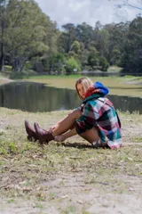 Botas acordonadas de cuero negro con suela track y detalle en cuero crudo en el talón.