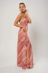 Vestido midi de crochet con diseño de ondas en tonos rojo, rosa y beige. Tiene un solo hombro y tajos laterales.