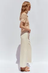 Pantalón de jean color crudo, de tiro alto, corte wide leg cropped y cinturón marrón.