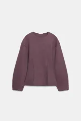 Jersey de cuello redondo y manga larga, confeccionado en tejido de punto elástico con trama compacta. Presenta un diseño con pinzas en la cintura que le otorgan una silueta entallada.